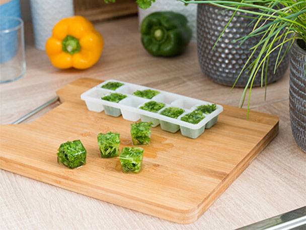Kräuter-Eiswürfel, Eiswürfelform und Schneidebrett.