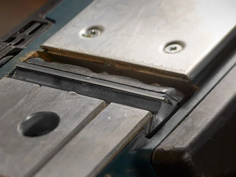 Hobelmesser und Tisch einer Hobelmaschine.