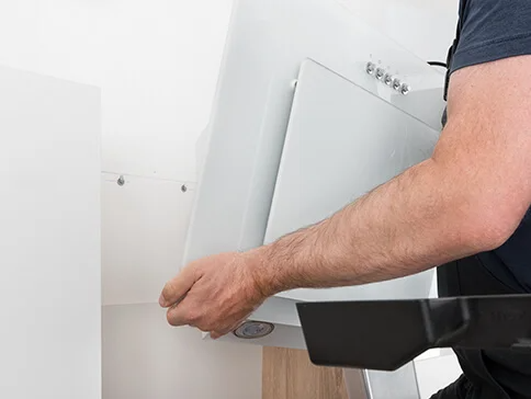 Einbau einer weißen Dunstabzugshaube.