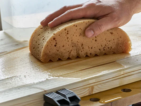 Großer Schwamm zur Behandlung einer Holzoberfläche.