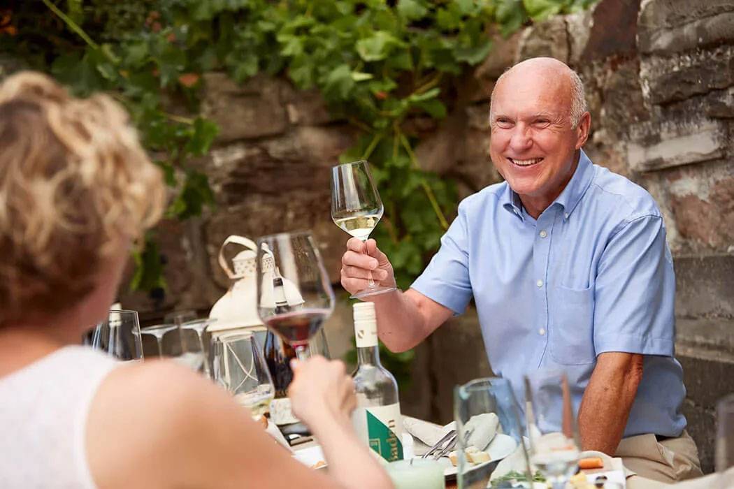 Wein und fröhliche Leute im Freien.