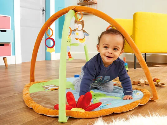 Baby-Spielmatte mit weichem Untergrund und Spielbogen mit Spielzeug.