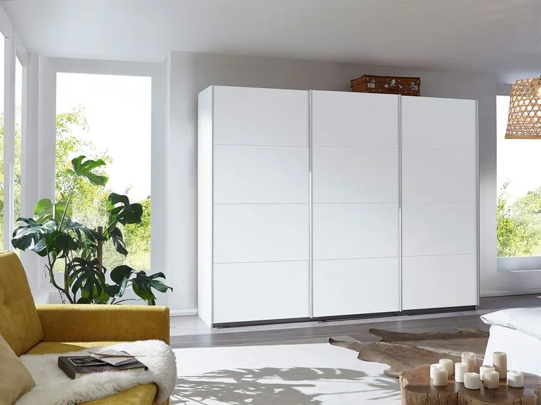 Weißer Schiebetürenschrank und gelbes Sofa.