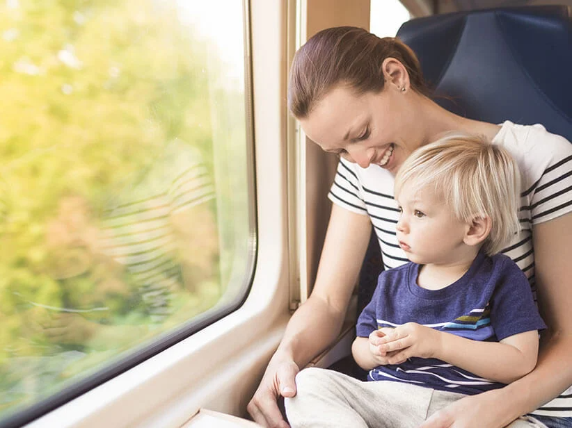 Mutter und Kind im Zug schauen aus dem Fenster.
