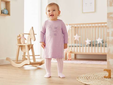 Lila Kleid und Strümpfe für Babys.