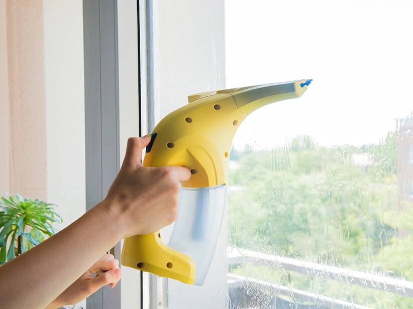 Fensterreinigung: Gelbes Fensterreinigungsgerät reinigt ein Fenster.