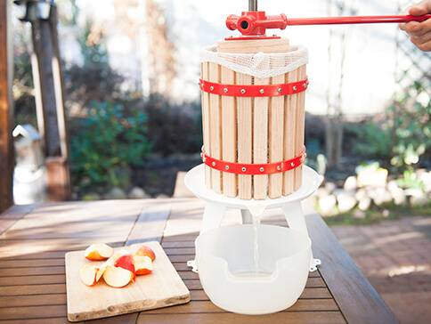 Apfelpresse und geschnittene Äpfel.