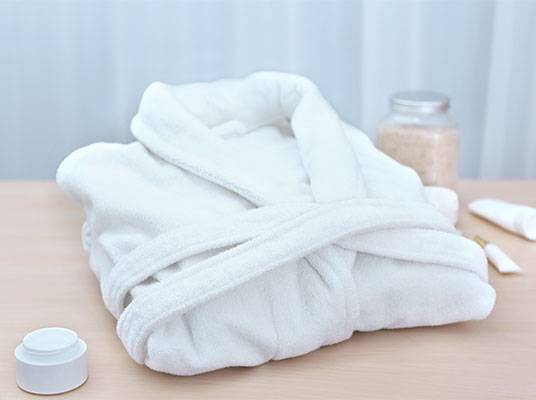 Weißer Bademantel und Badutensilien.