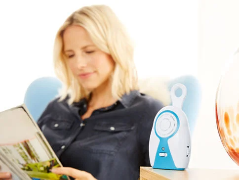 Babyphone und entspannte Mutter mit Magazin.