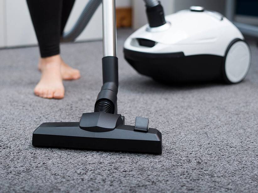 Teppich wird mit Staubsauger gesaugt.