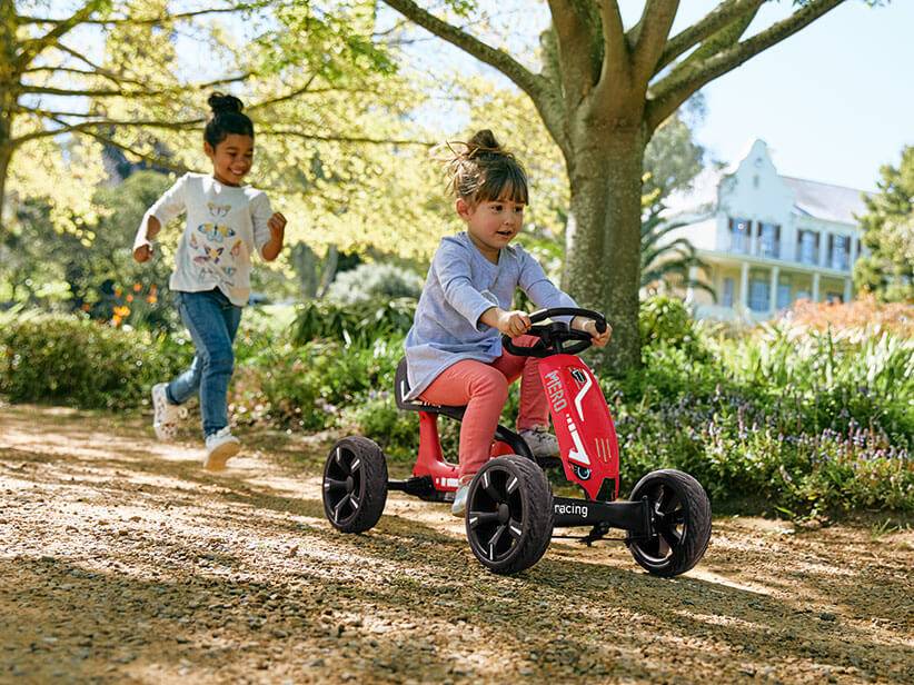 Kinder spielen draußen mit einem MERO Go-Kart.