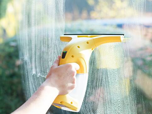 Fensterreinigung mit einem Fensterreiniger.