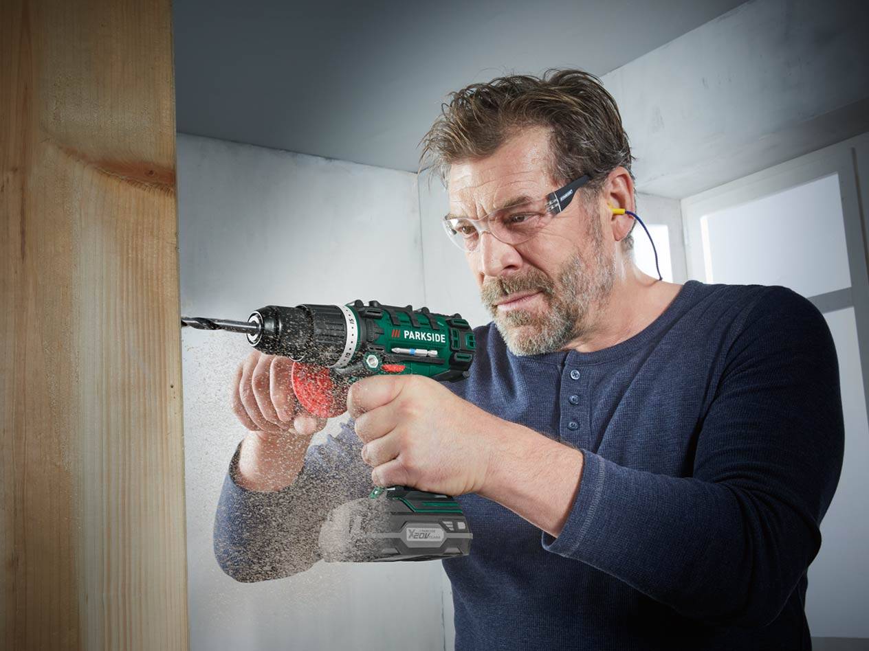 Mann bohrt Holz mit einer Parkside Bohrmaschine.