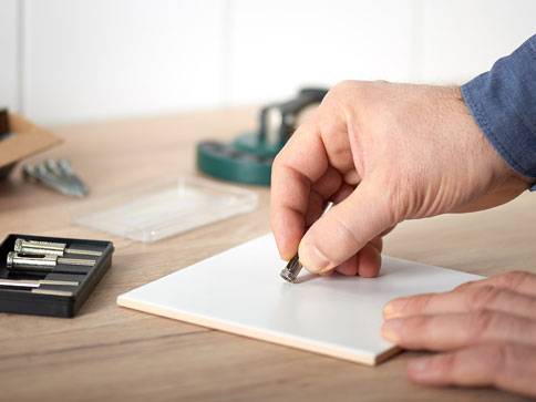 Fliesen und Schrauben: manuelle Montage.