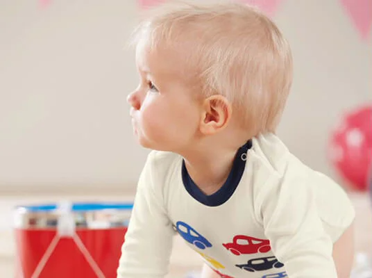 Baby trägt Kleidung mit Automotiven.