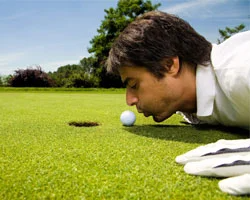 Golfer küsst Golfball vor dem Putt.