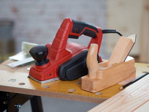 Elektrische Hobel und Handhobel auf dem Werktisch.