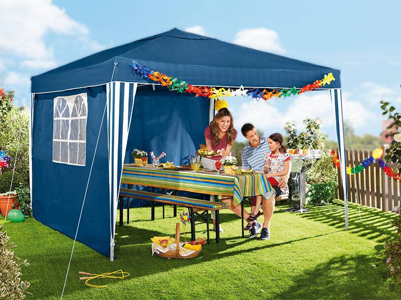 Gartenparty: blaues Pavillon, Gartentisch und Familie.
