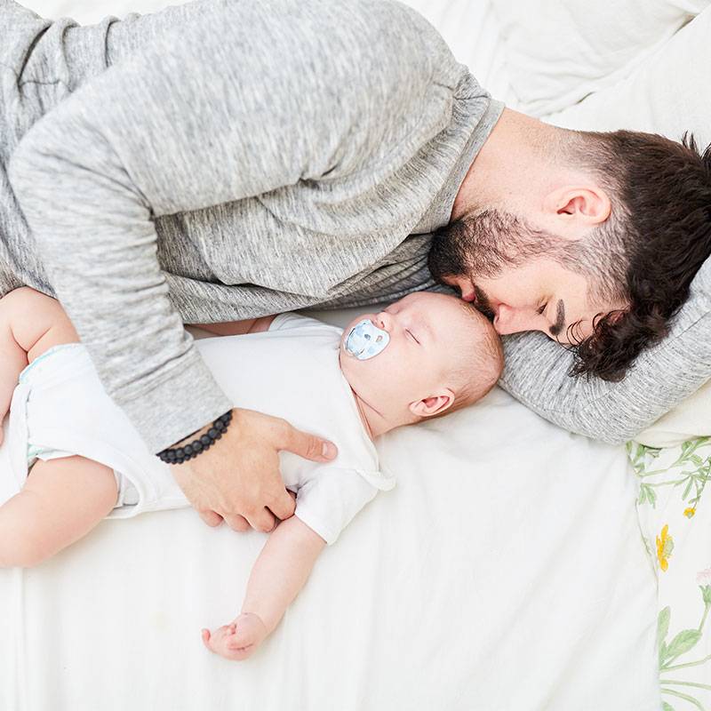 Vater und Baby schlafen zusammen.