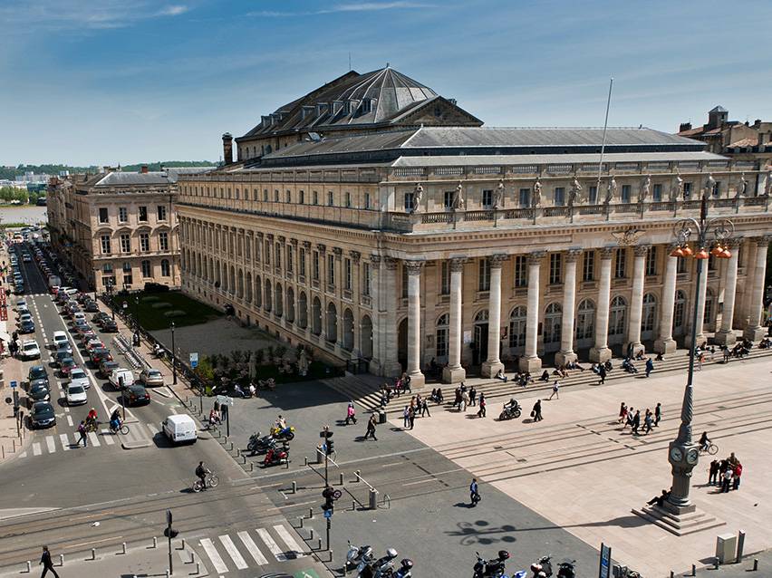 Luftaufnahme des Grand Théâtre de Bordeaux mit Menschen und Autos auf der Straße.