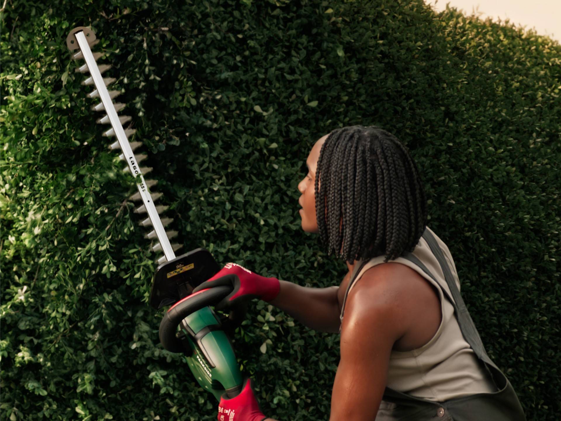 Person schneidet Hecke mit einer Parkside Heckenschere.