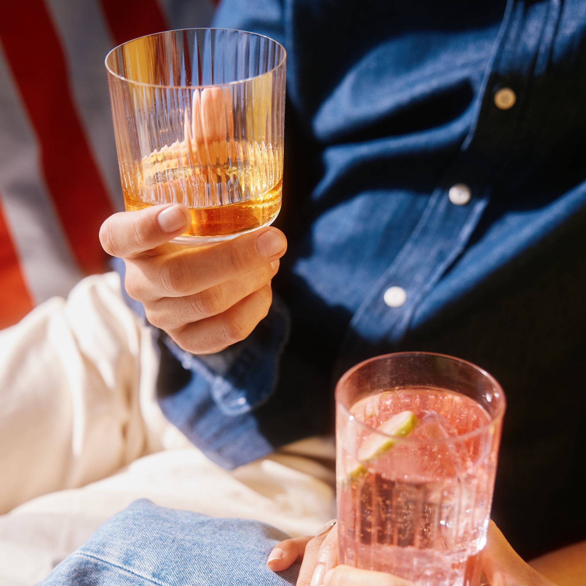 Whisky und ein rosa Cocktail in Gläsern.