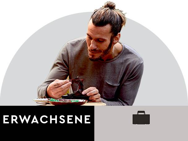 Mann macht Handarbeit; Perlen und Miniaturmodell.