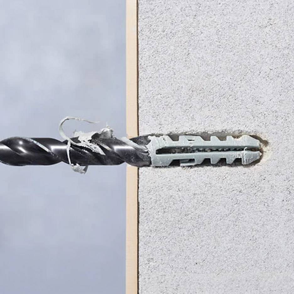 Bohrer bohrt in eine Wand mit einem Befestigungsdübel.