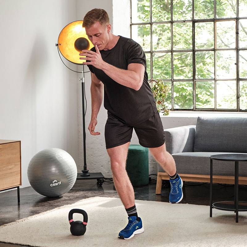 Mann trainiert mit Crivit Medizinball, Kettlebell und Gymnastikball