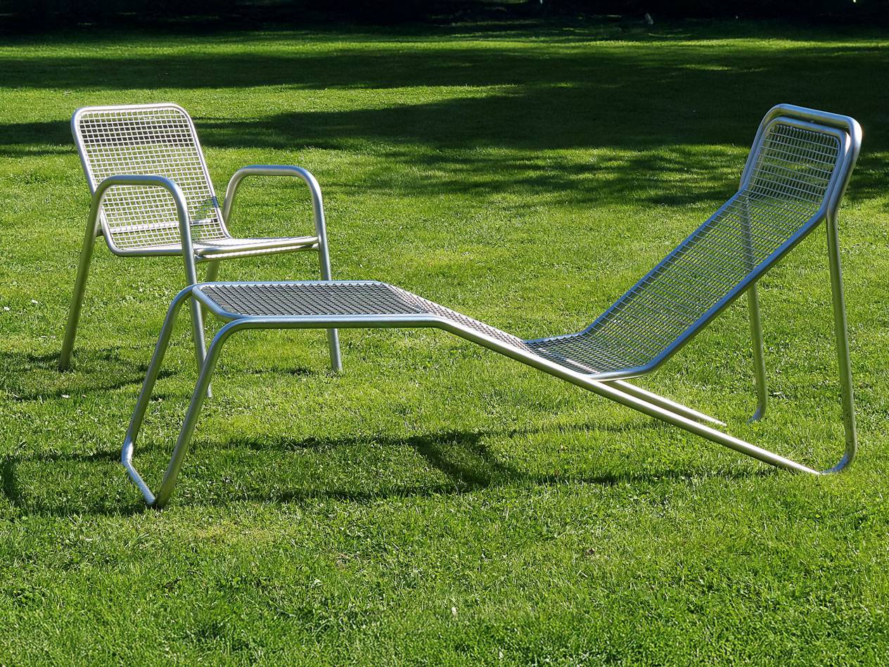 Metall-Liegestuhl und Stuhl im Rasen.