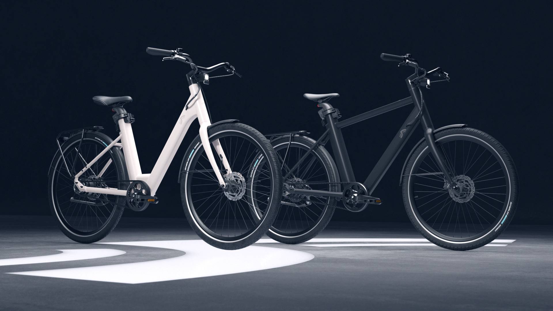 Zwei moderne E-Bikes: ein weißes, ein schwarzes.
