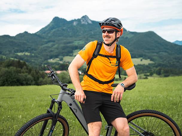 E-Bike und Radfahrer in einer Berglandschaft.