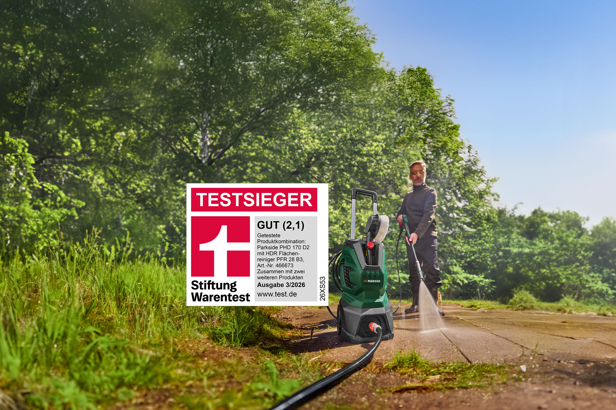 Mann reinigt Weg mit Hochdruckreiniger, daneben die „GUT (2,1)“ Bewertung von Stiftung Warentest.