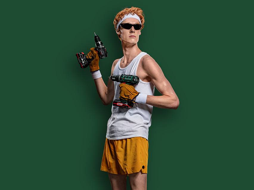 Mann mit zwei Bohrmaschinen.