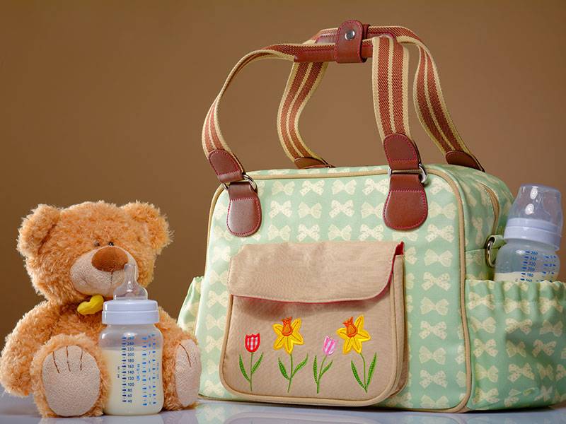 Wickeltasche, Babyflasche und Teddybär.