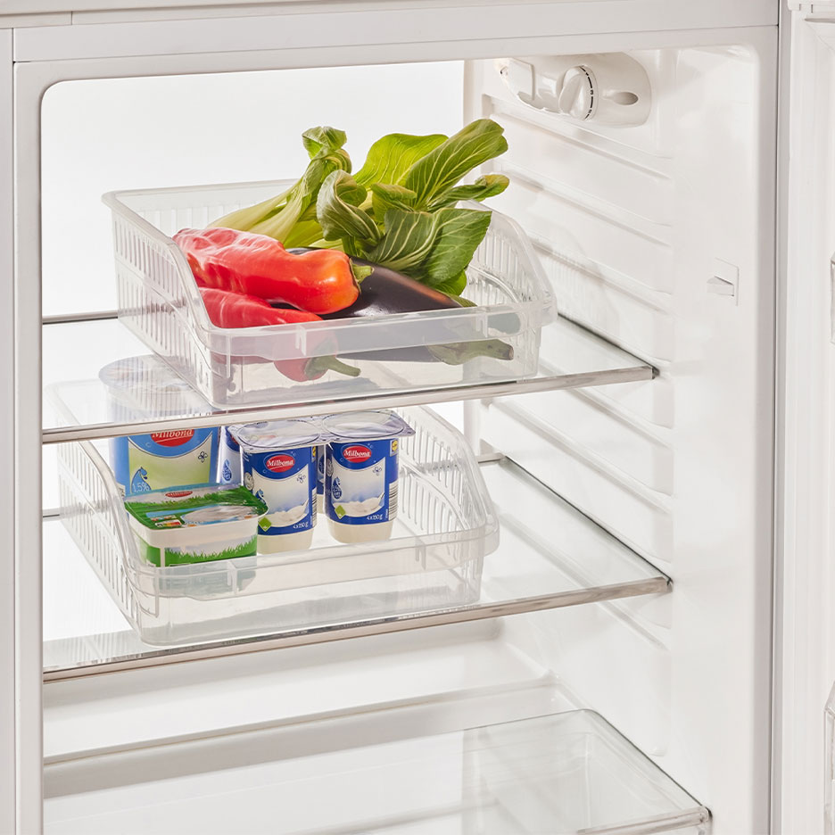 Kühlschrank mit transparenten Organizern, gefüllt mit Gemüse, Joghurt und Käse.
