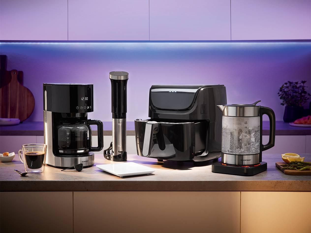 Kaffeemaschine, Heißluftfritteuse, Stabmixer und Wasserkocher in der Küche.