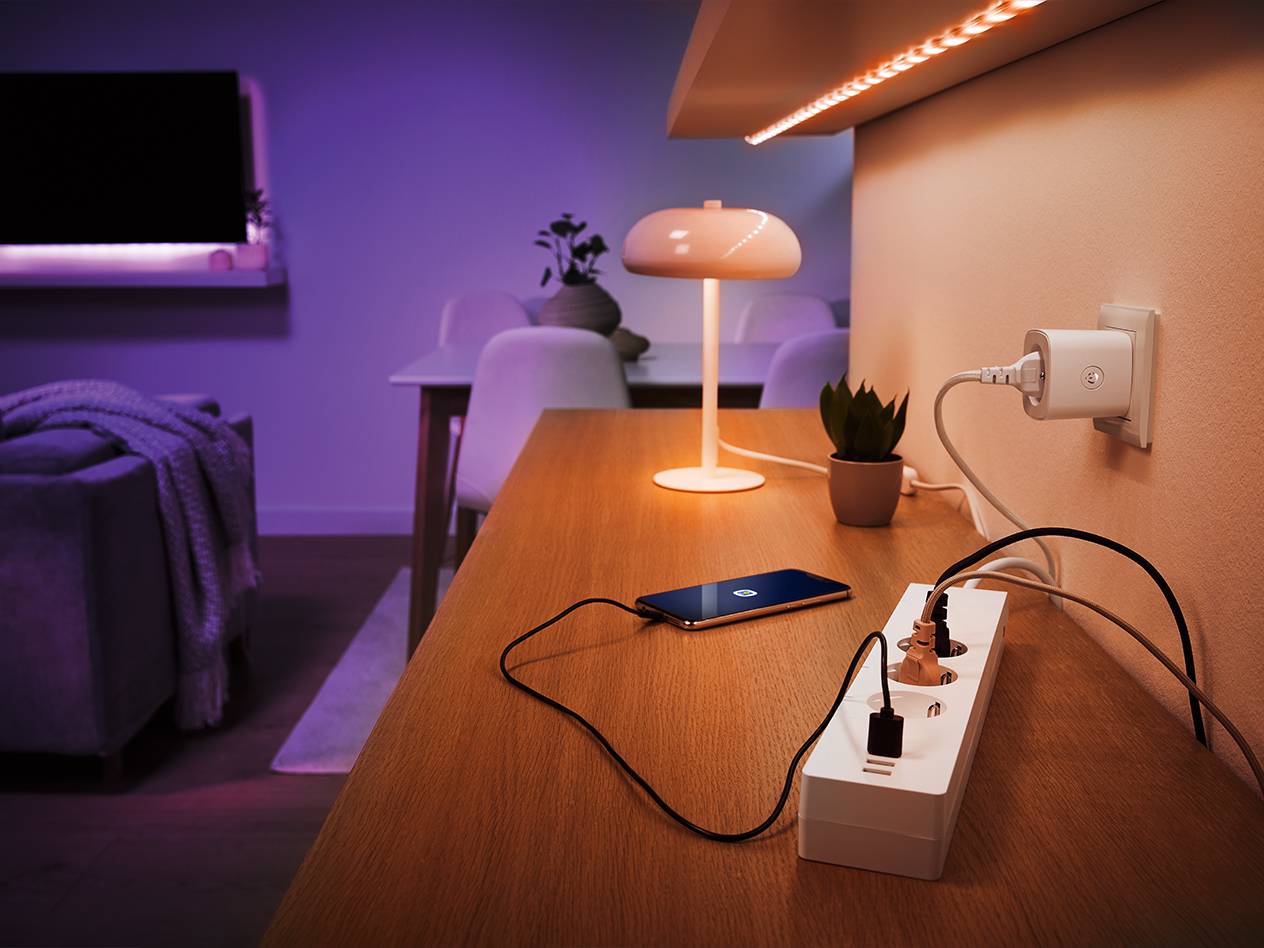 Smarte Steckdose, Steckerleiste und Philips Tischlampe in einem eleganten Wohnzimmer.
