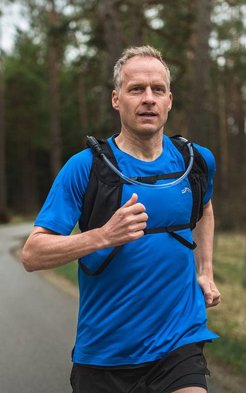 Mann läuft mit Salomon Laufweste.