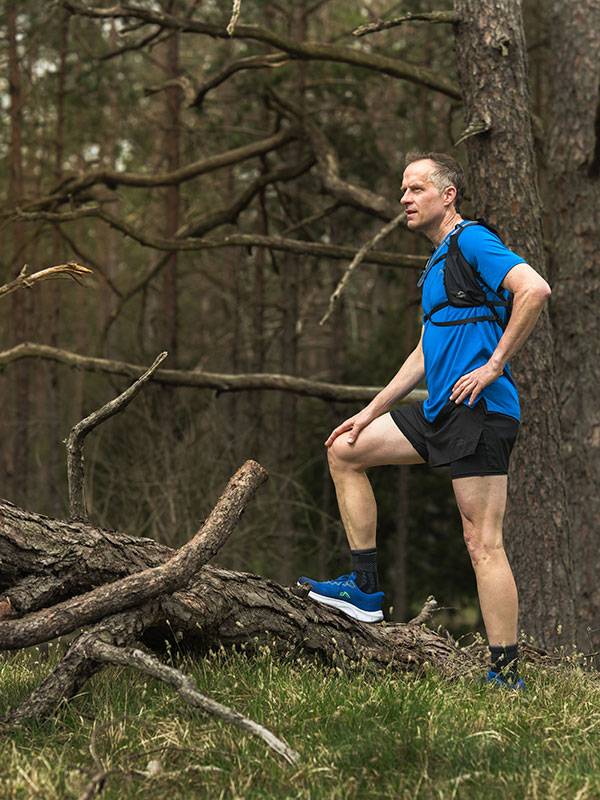 Trailrunning-Bekleidung und Schuhe im Wald.