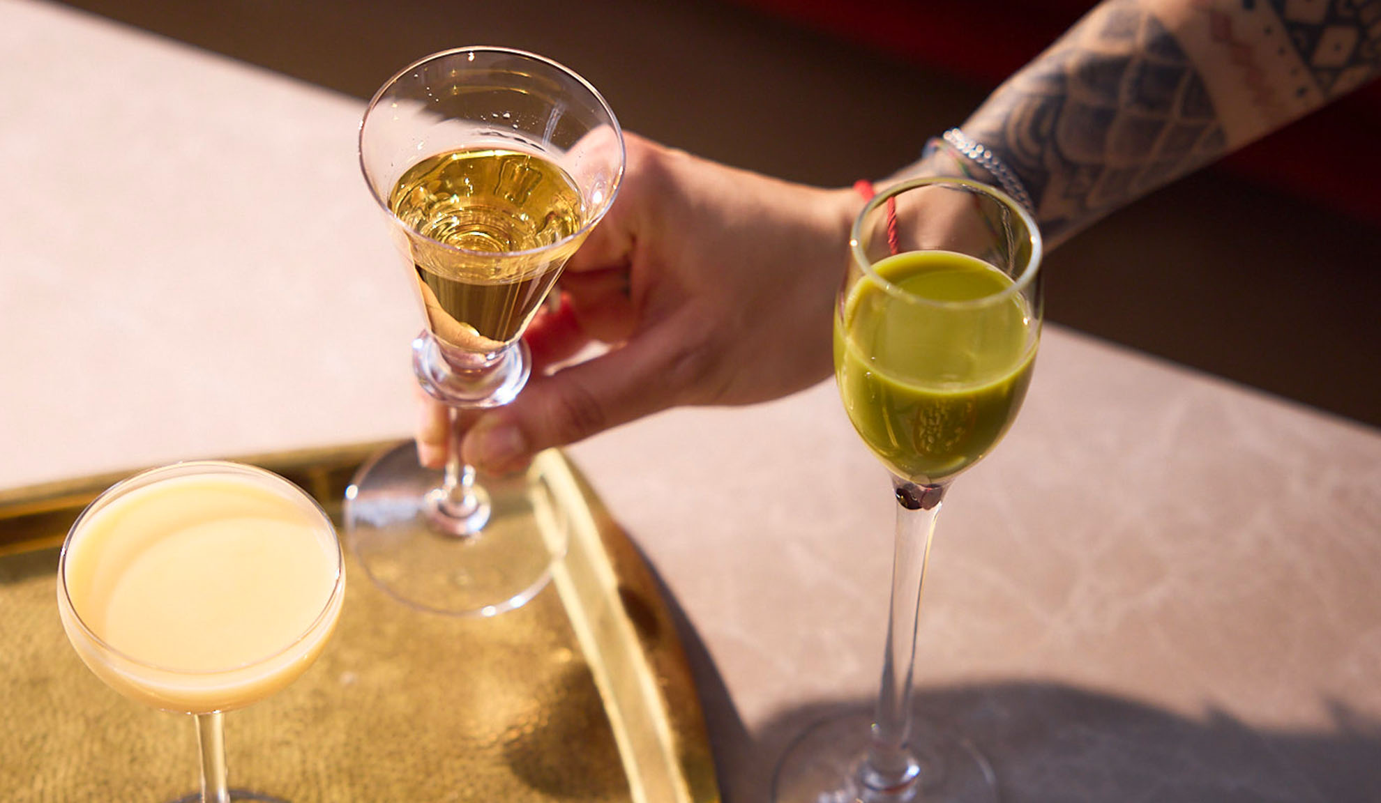 Liköre in Gläsern: gelb, grün, cremig.