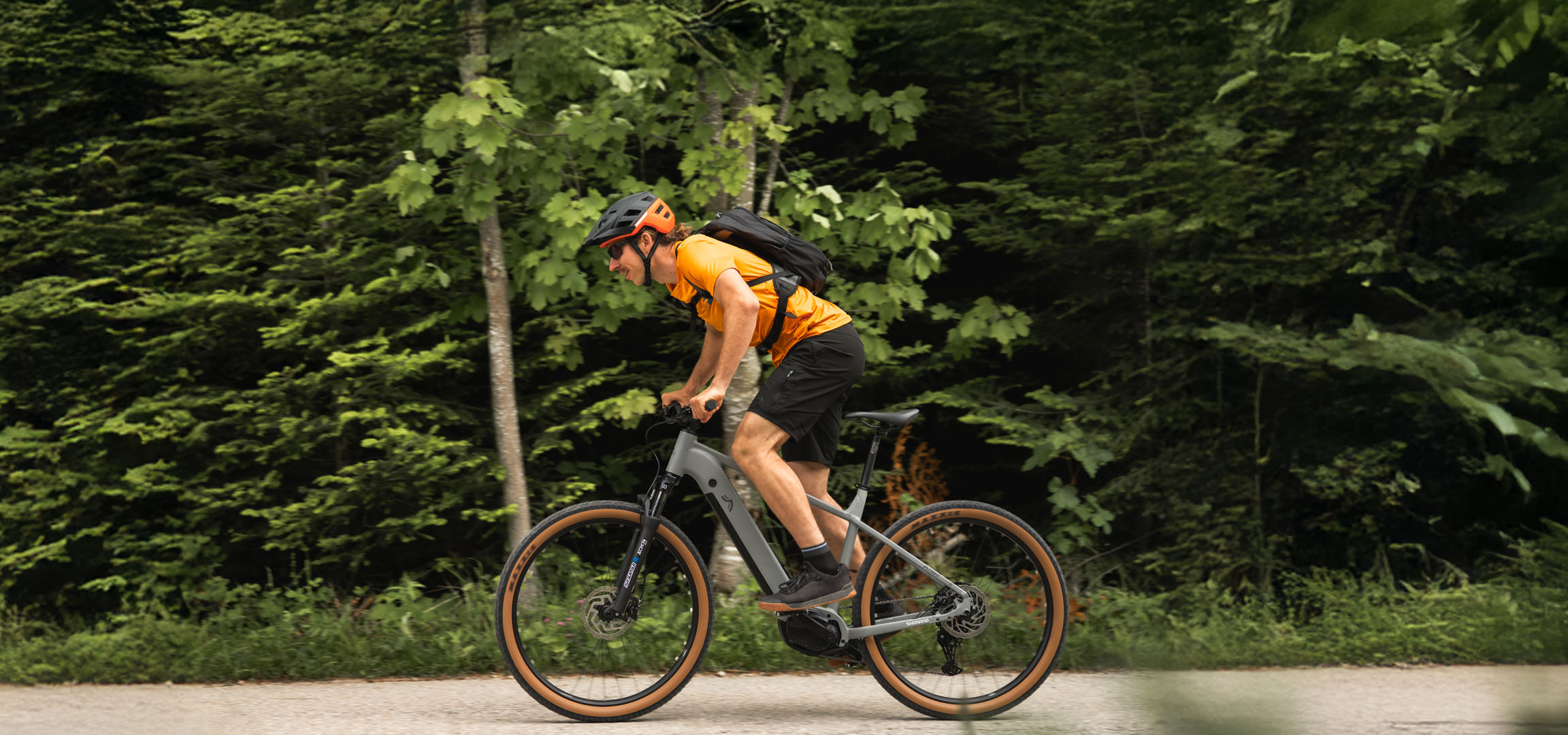 Ein Mann fährt mit einem Cube E-Bike auf einem Waldweg.
