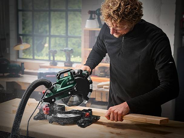 Mann verwendet eine Einhell Kapp- und Gehrungssäge für Holz.