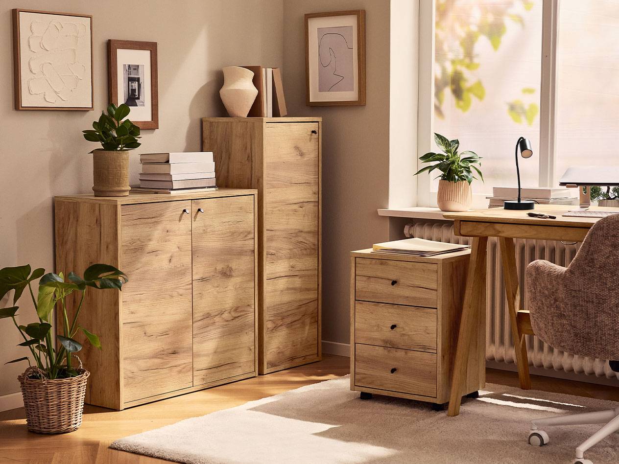 Ein Home-Office mit hellen Holzschränken, einem Bürostuhl und einer Schreibtischlampe.