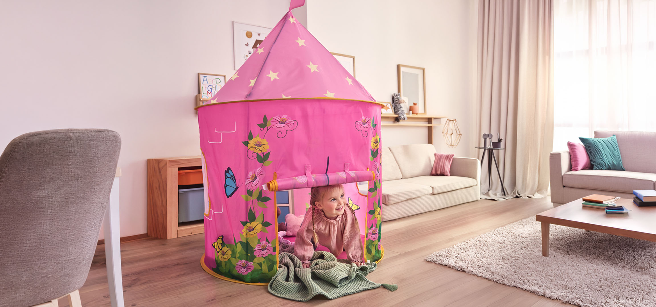 Rosa Kinderspielzelt in Form eines Schlosses im Wohnzimmer mit Essbereich.