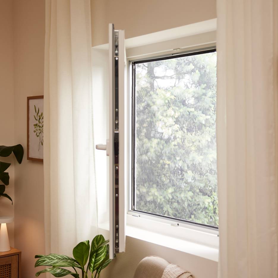 Offenes Fenster mit Fliegengitter, weißen Vorhängen und Zimmerpflanzen.