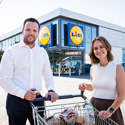 Personen in einem Lidl Supermarkt mit einem Einkaufswagen.