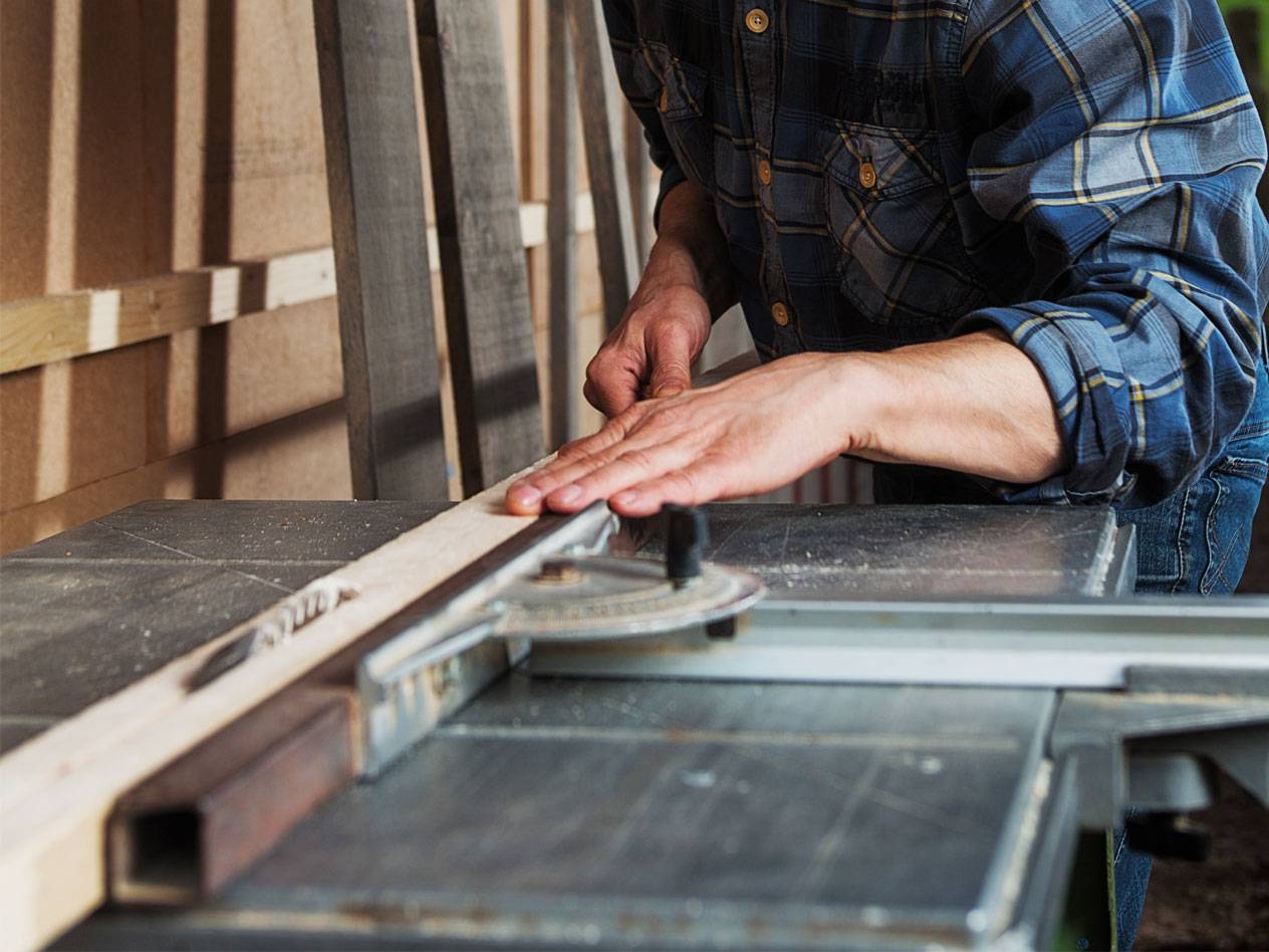 Holzbearbeitung mit einer Tischkreissäge.