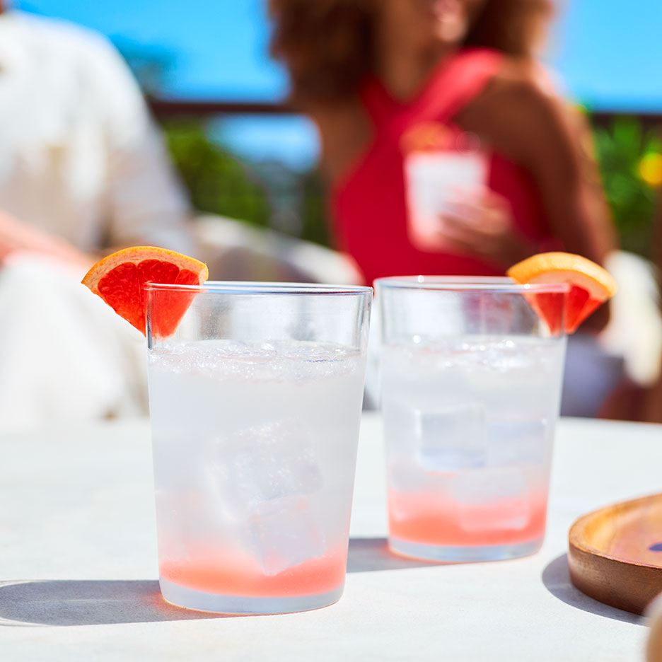 Zwei Gläser erfrischendes Grapefruitgetränk auf einem sonnigen Tisch.