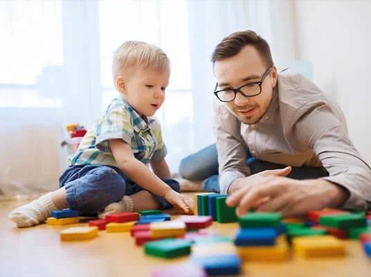 Vater und Sohn spielen mit Holzklötzchen.
